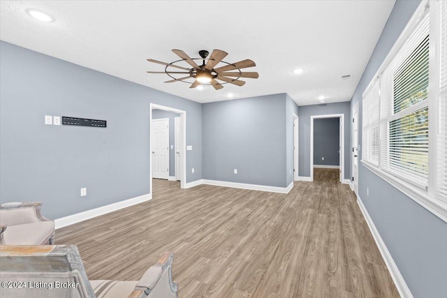 unfurnished living room with light wood-type flooring and ceiling fan