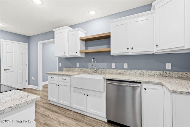 kitchen featuring light stone counters, sink, stainless steel dishwasher, white cabinetry, and light wood-type flooring