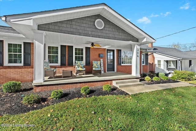 exterior space with a porch, ceiling fan, and a yard