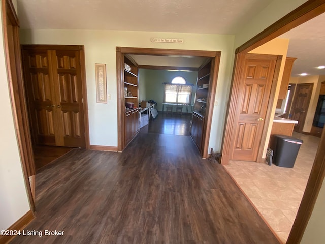 hall featuring dark hardwood / wood-style floors and built in features