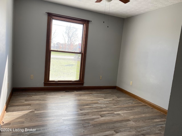 unfurnished room with hardwood / wood-style floors, a textured ceiling, and ceiling fan