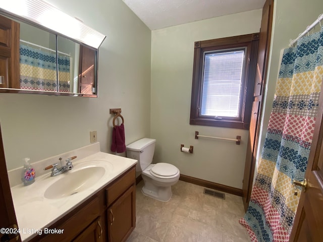 bathroom featuring vanity, walk in shower, and toilet