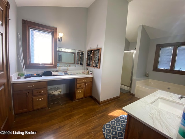 bathroom featuring hardwood / wood-style flooring, vanity, vaulted ceiling, and plus walk in shower