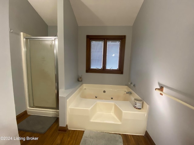 bathroom with hardwood / wood-style flooring and shower with separate bathtub