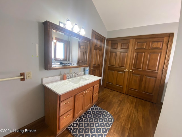 bathroom featuring vanity, vaulted ceiling, and hardwood / wood-style floors