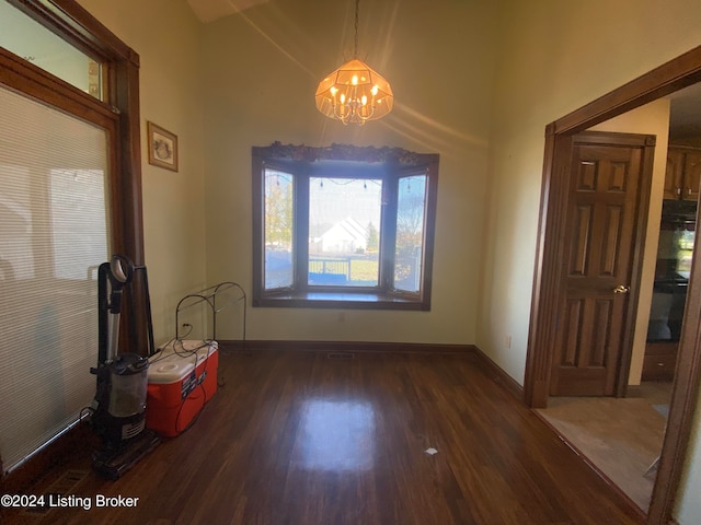 unfurnished dining area featuring dark hardwood / wood-style flooring and a notable chandelier