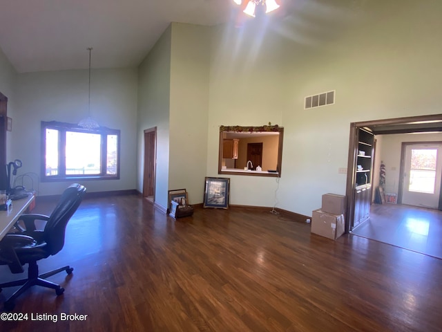 home office featuring high vaulted ceiling and dark hardwood / wood-style floors