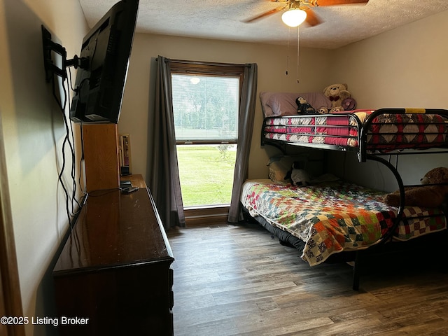 bedroom with multiple windows, hardwood / wood-style floors, a textured ceiling, and ceiling fan