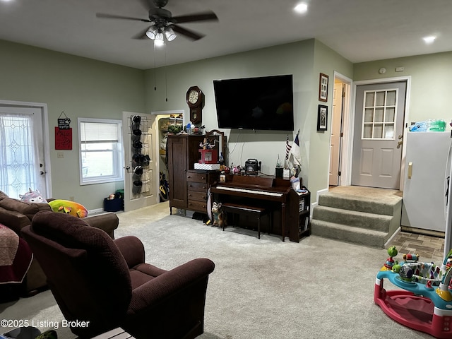 carpeted living room with ceiling fan