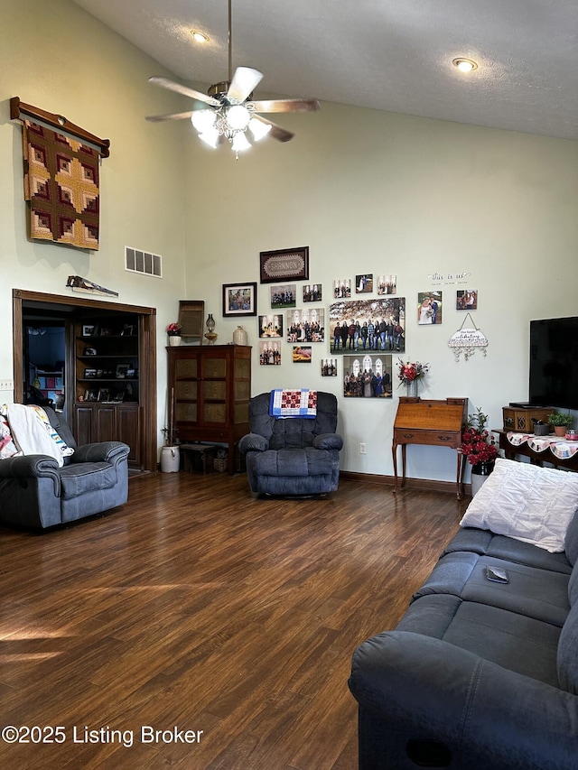 living room with ceiling fan, lofted ceiling, a textured ceiling, and dark hardwood / wood-style flooring