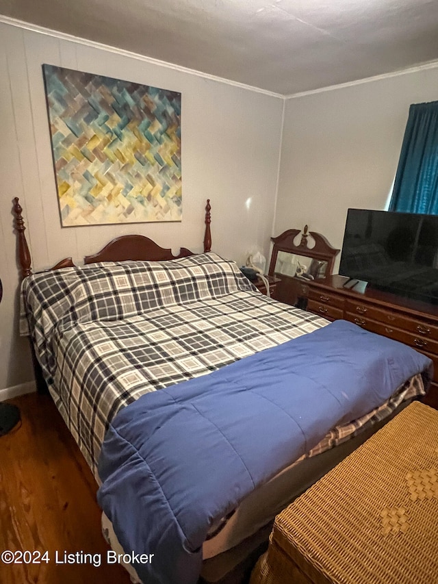 bedroom with dark hardwood / wood-style floors and crown molding