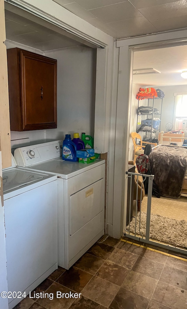 clothes washing area with washer and clothes dryer and cabinets