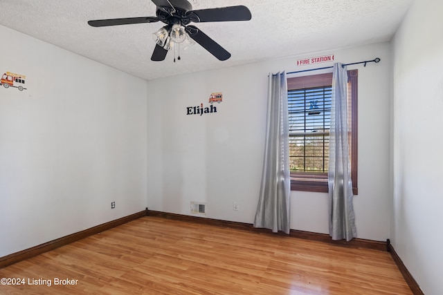 empty room featuring ceiling fan, a textured ceiling, and light hardwood / wood-style floors