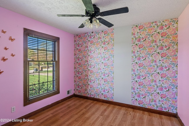 spare room featuring hardwood / wood-style floors, ceiling fan, and a textured ceiling