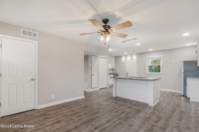 kitchen featuring ceiling fan, wood-type flooring, pendant lighting, white cabinets, and a center island