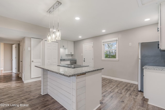 kitchen featuring a kitchen island, decorative light fixtures, light hardwood / wood-style flooring, white cabinetry, and stainless steel refrigerator