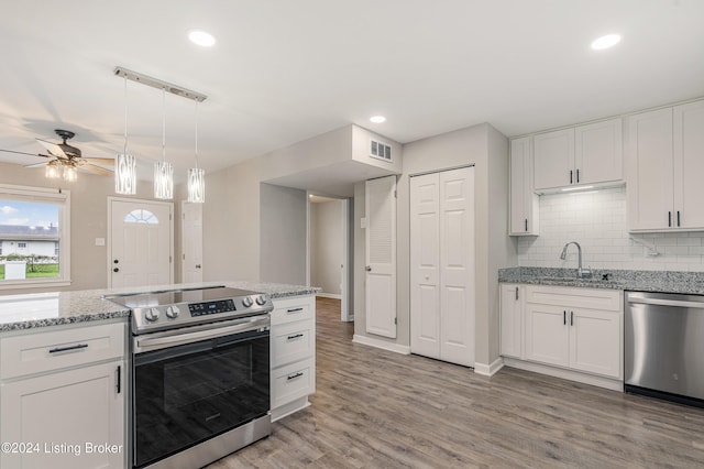 kitchen with light wood-type flooring, white cabinetry, sink, and appliances with stainless steel finishes