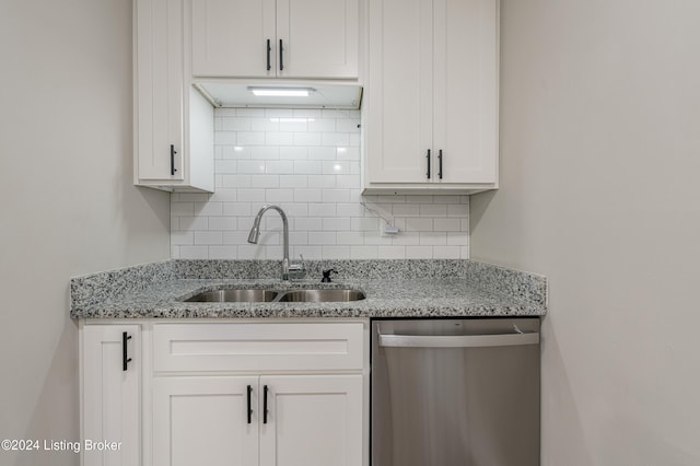 kitchen featuring light stone countertops, sink, stainless steel dishwasher, decorative backsplash, and white cabinets