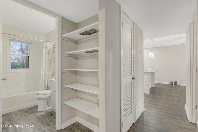 bathroom featuring hardwood / wood-style floors, shower / tub combo, and toilet