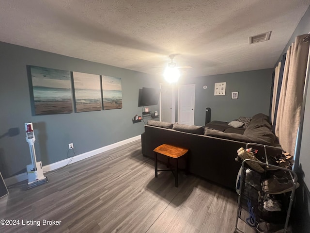 living room with a textured ceiling, hardwood / wood-style floors, and ceiling fan