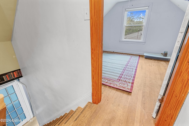 bonus room with wood-type flooring and vaulted ceiling