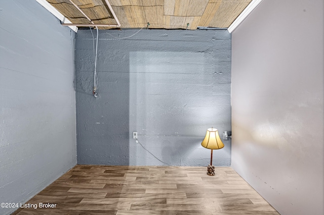 basement with wood-type flooring and crown molding