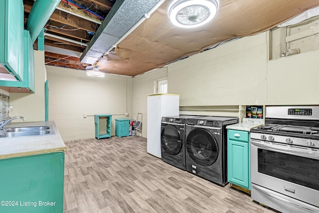 laundry area featuring washer and dryer, light wood-type flooring, and sink