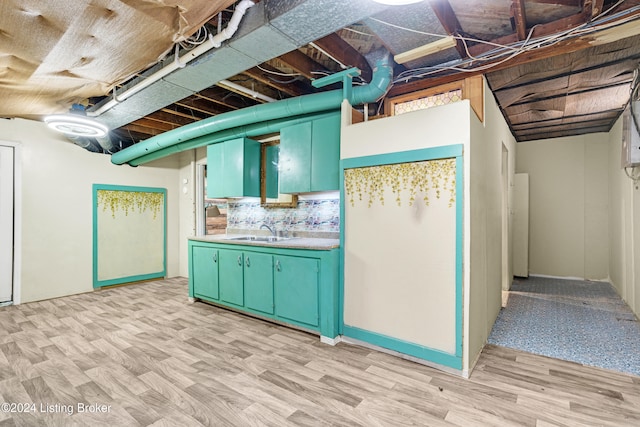 basement featuring light hardwood / wood-style flooring and sink