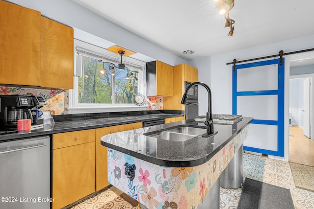 kitchen featuring dishwasher, hanging light fixtures, a barn door, backsplash, and dark stone countertops