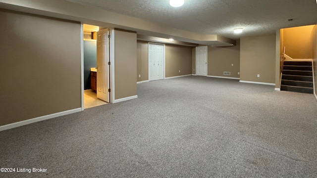 basement with carpet and a textured ceiling