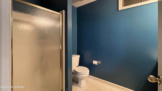 bathroom with tile patterned flooring, toilet, and walk in shower