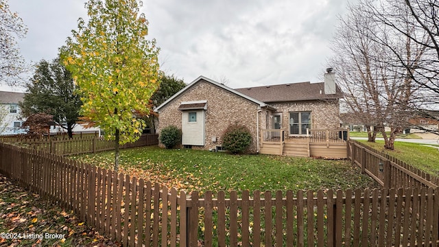 rear view of property with a deck and a lawn