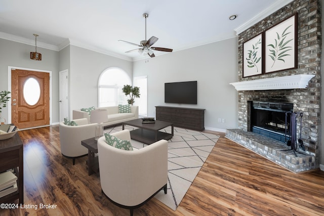 living room featuring ceiling fan, a fireplace, ornamental molding, and hardwood / wood-style flooring