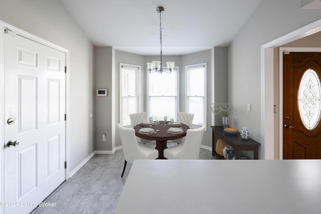 dining area with a notable chandelier, lofted ceiling, and light tile patterned floors