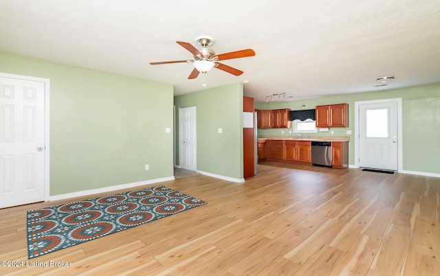 unfurnished living room featuring ceiling fan, light wood-type flooring, and sink