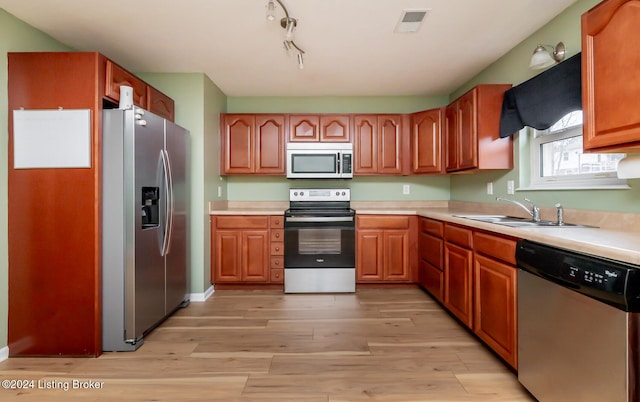 kitchen with light hardwood / wood-style floors, sink, and stainless steel appliances