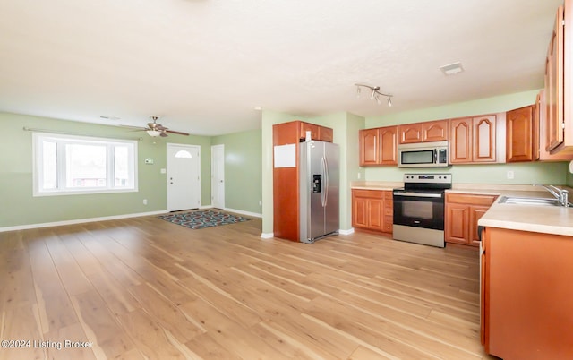 kitchen featuring ceiling fan, light wood-type flooring, sink, and appliances with stainless steel finishes