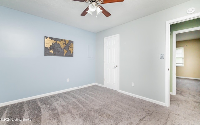 carpeted spare room featuring ceiling fan