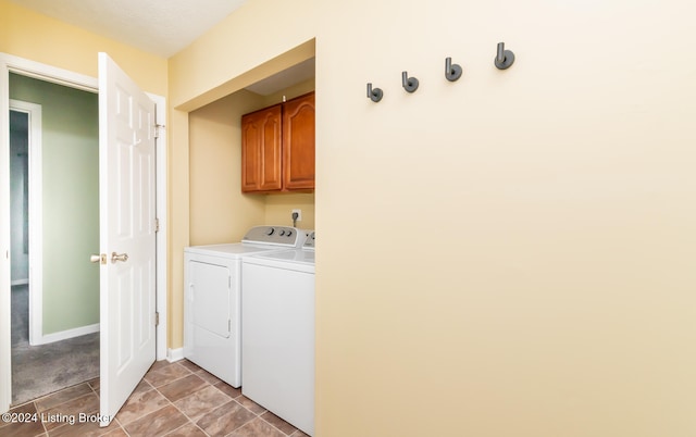 laundry room with washing machine and dryer and cabinets