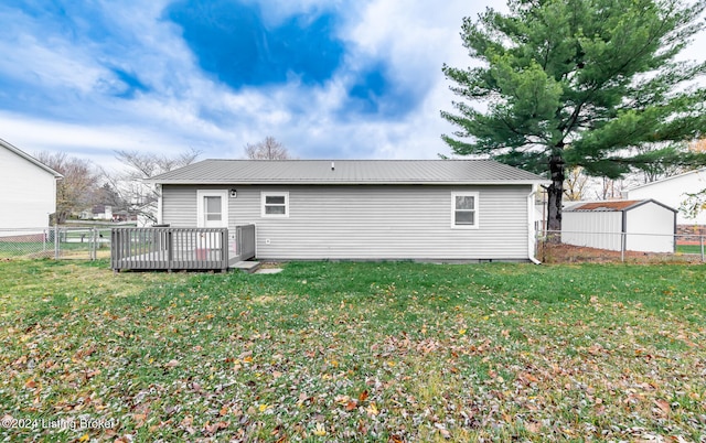 back of house with a wooden deck and a lawn