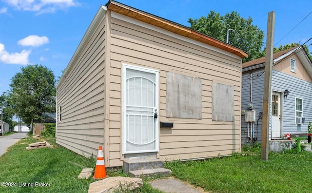 view of outbuilding with a lawn and cooling unit