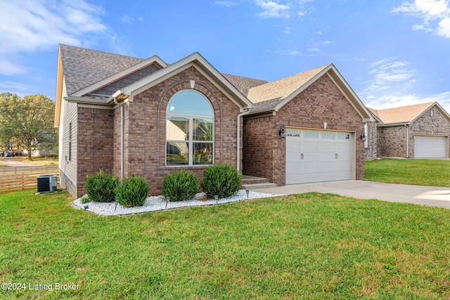 ranch-style house with a garage, cooling unit, and a front lawn