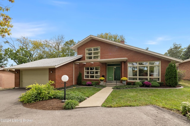 view of front of house featuring a front lawn and a garage