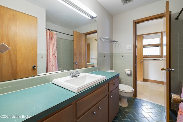 bathroom featuring tile patterned flooring, vanity, tile walls, and toilet