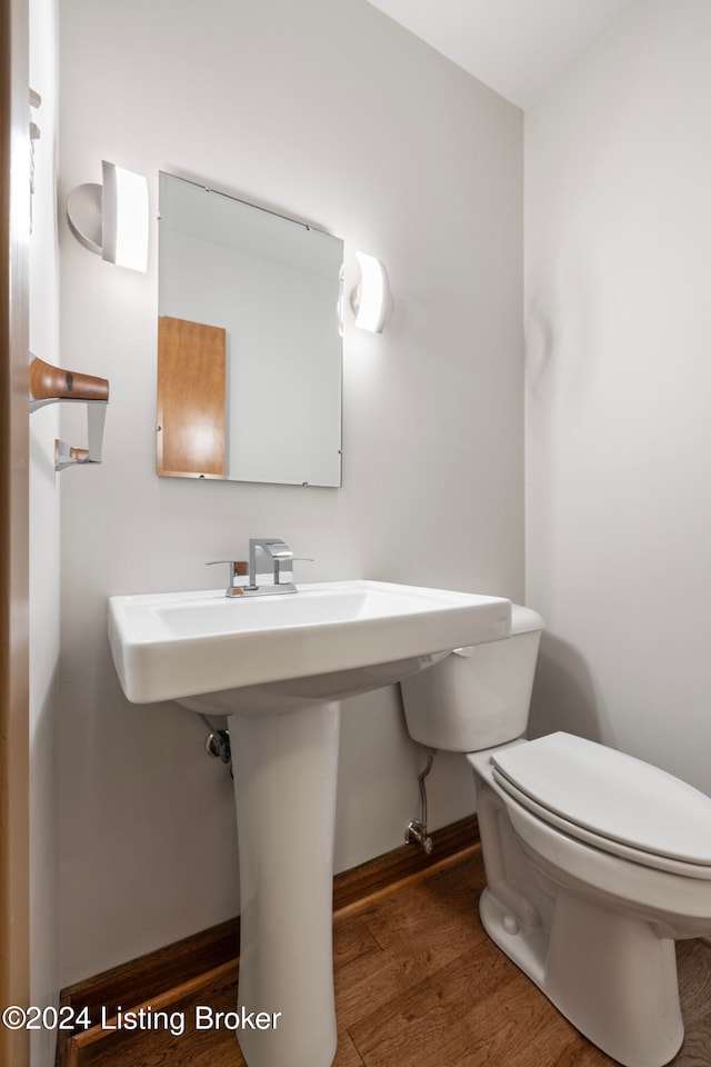 bathroom with hardwood / wood-style flooring and toilet