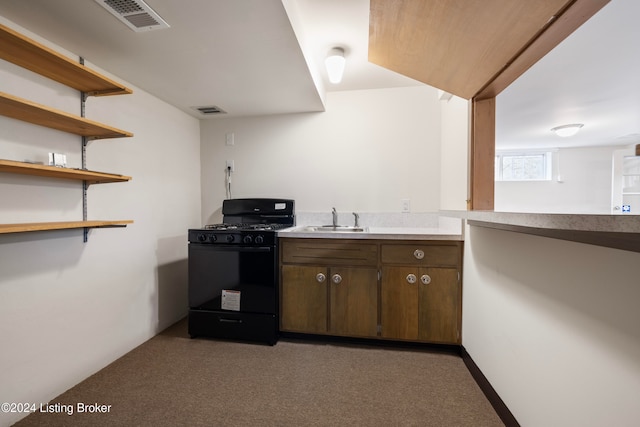 kitchen featuring black gas range, sink, and dark colored carpet