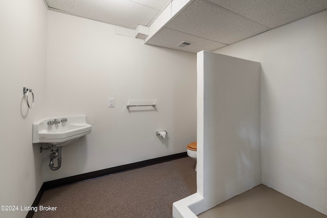 bathroom with a paneled ceiling and toilet