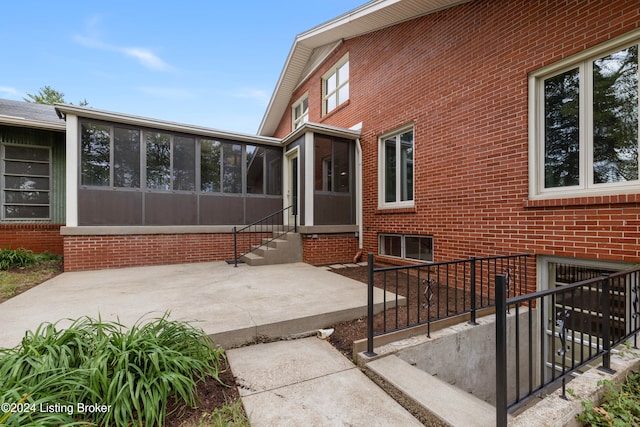 view of home's exterior with a patio area and a sunroom