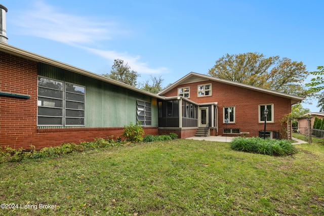 back of house featuring a sunroom, a yard, and cooling unit