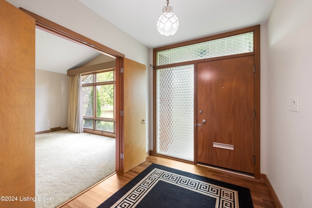 foyer featuring hardwood / wood-style floors and vaulted ceiling